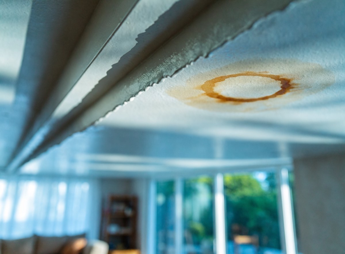 Brown water stain spreading across a ceiling below a leak